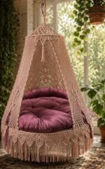 60 inch natural light pink macrame swing with pink cushion near a window