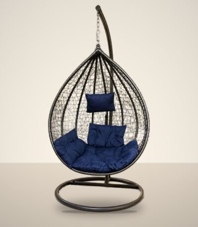 Black HDPE wicker hanging egg chair swing with stand and navy blue cushions, studio background