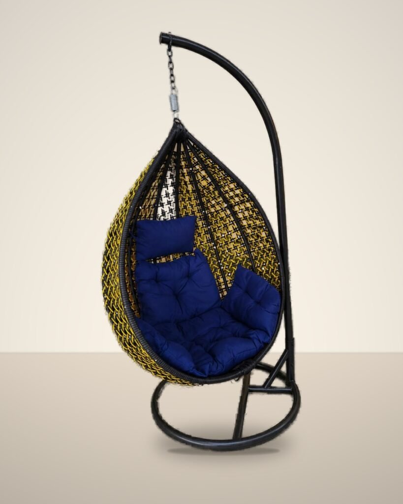Black and yellow HDPE wicker hanging egg chair swing with stand and navy blue cushions, studio background