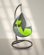 Grey HDPE wicker hanging teardrop chair swing with stand and lime green cushions in sunlight
